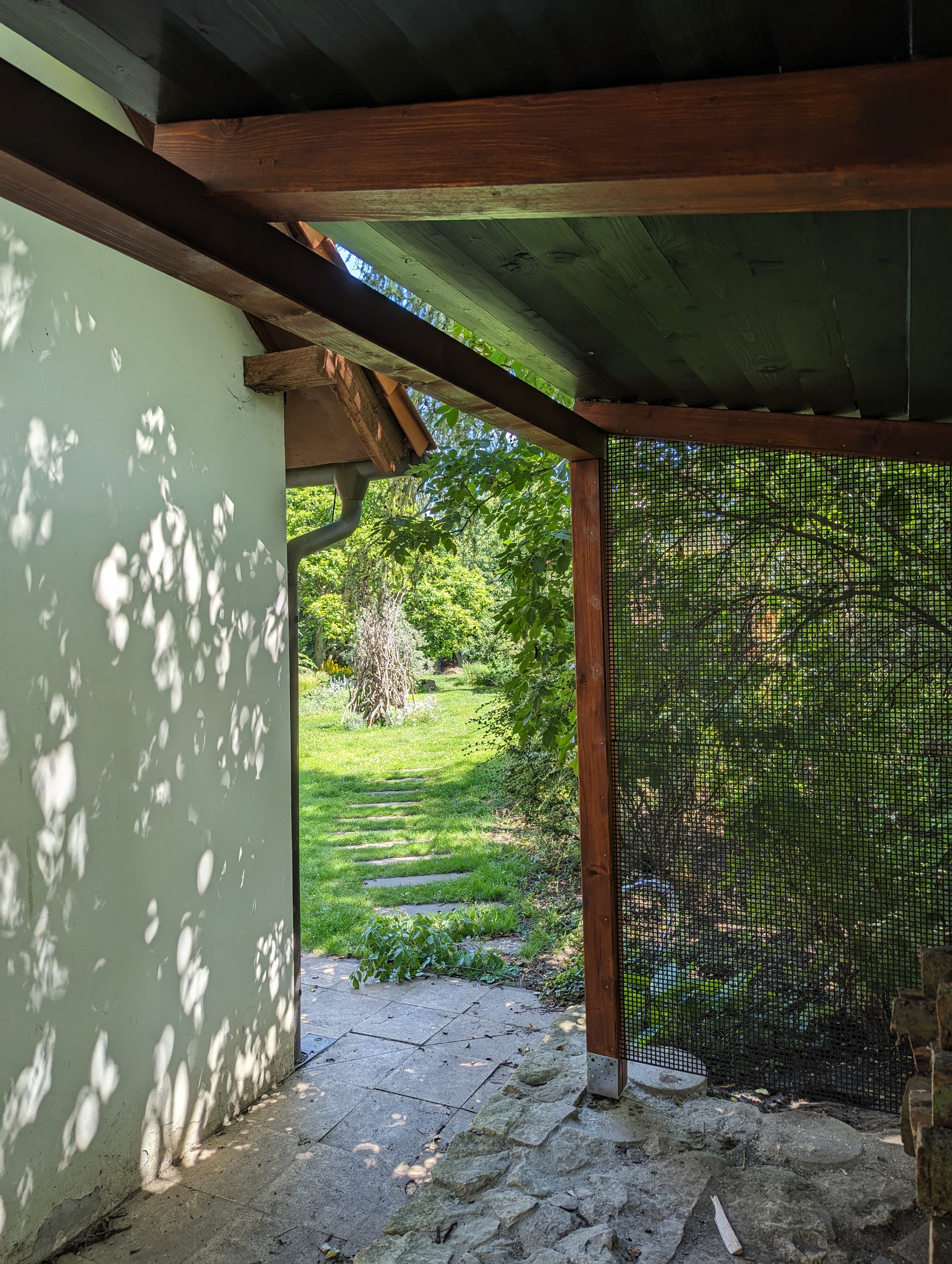 Woodgon — woodshed in a garden with mature trees behind