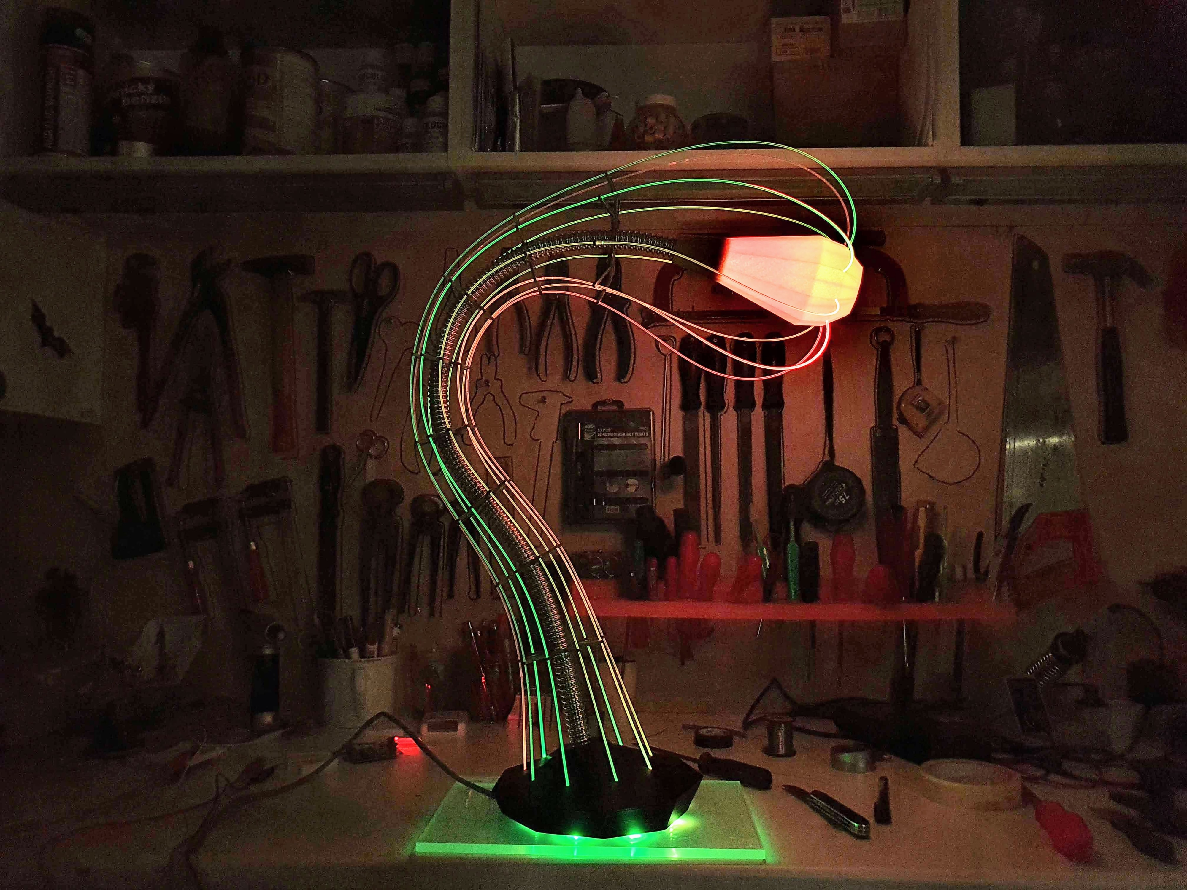 IXFID — curved lamp with green and orange gradient glow in a workshop