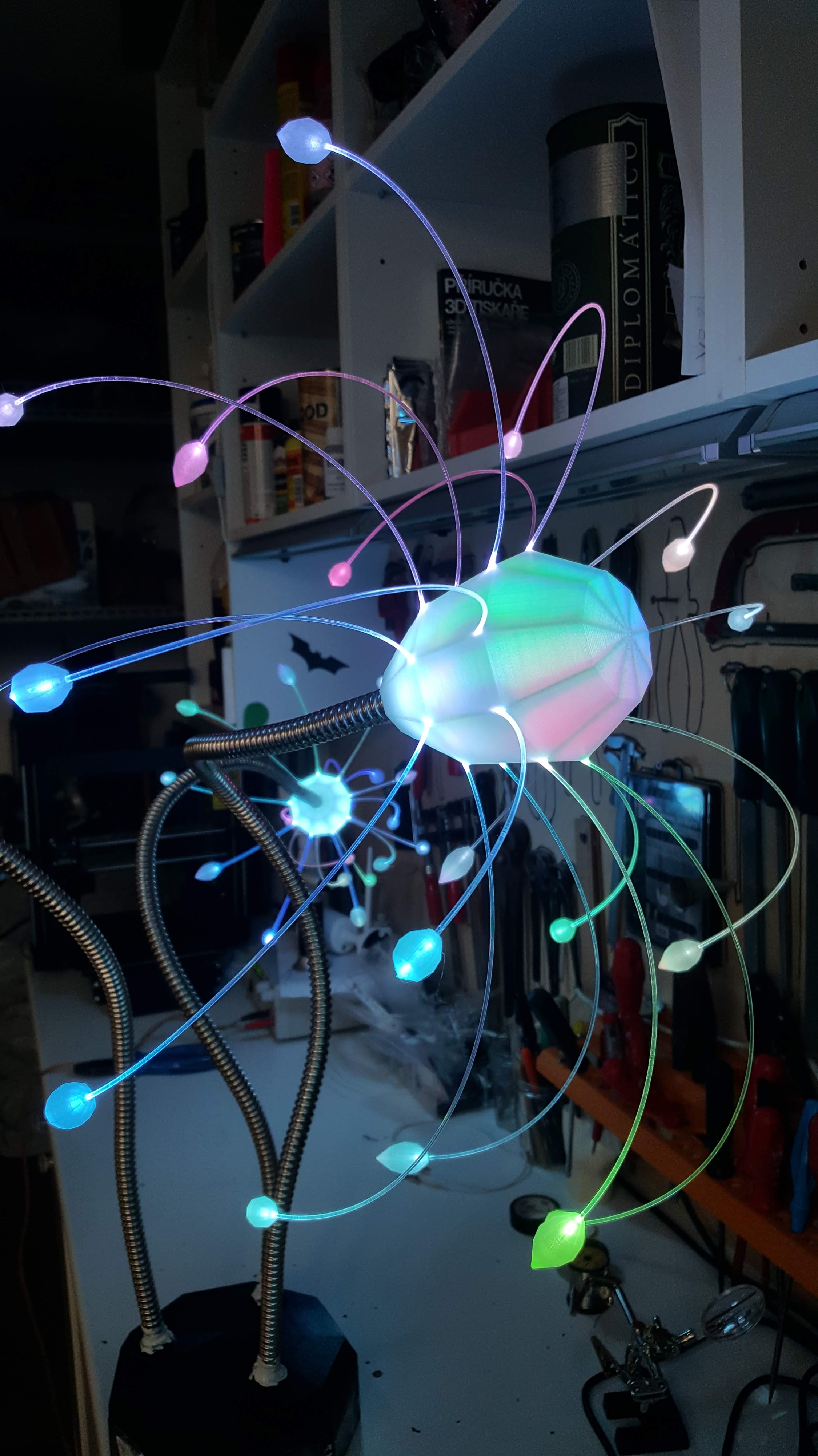 Tris — three glowing sculptures in a dark garden
