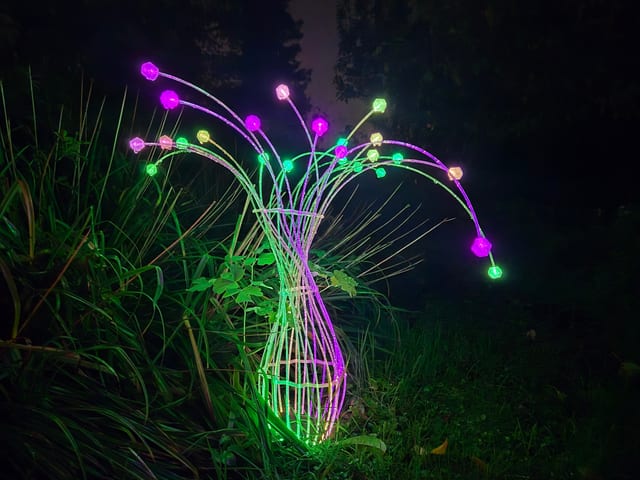 Fiberina outdoor light sculpture like a vase of glowing stems at night