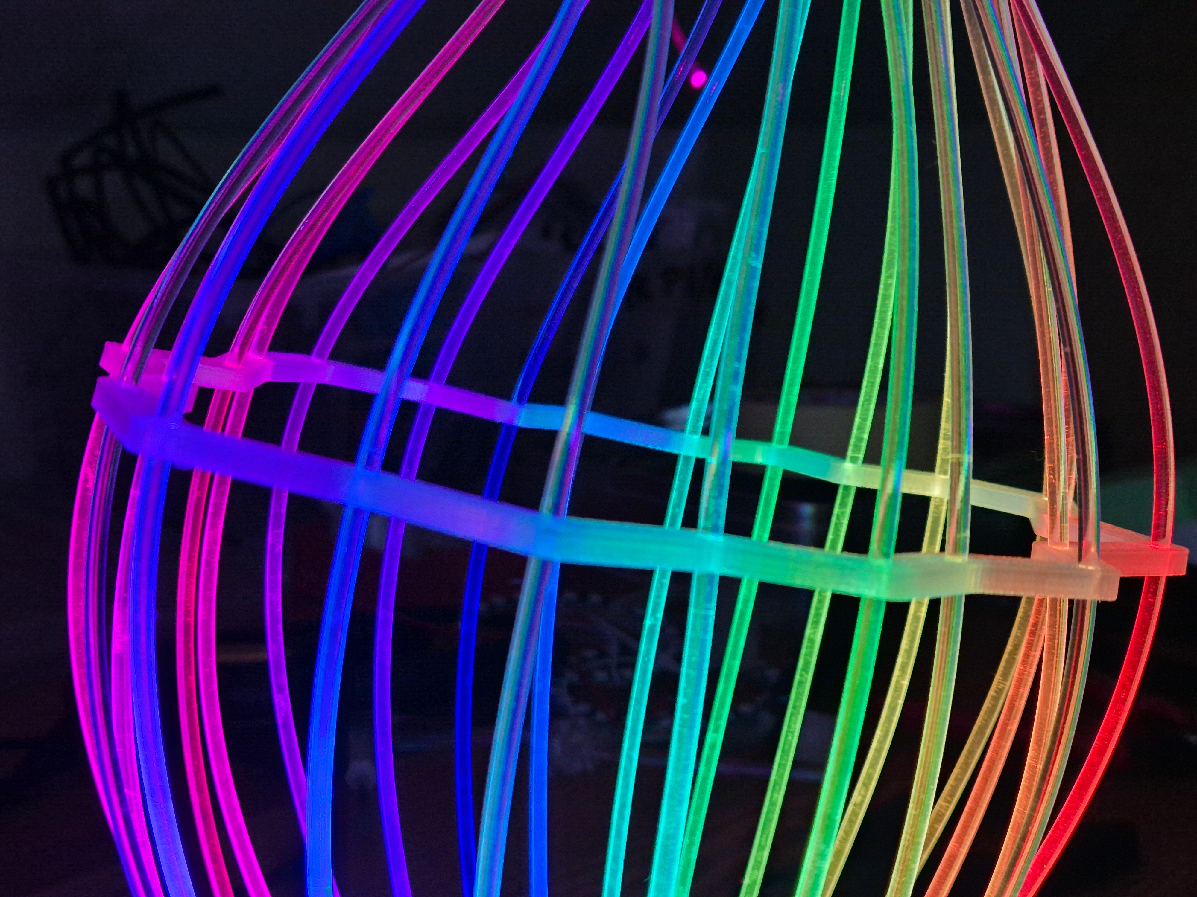 Fiberina — rainbow glowing cage-like light sculpture close-up