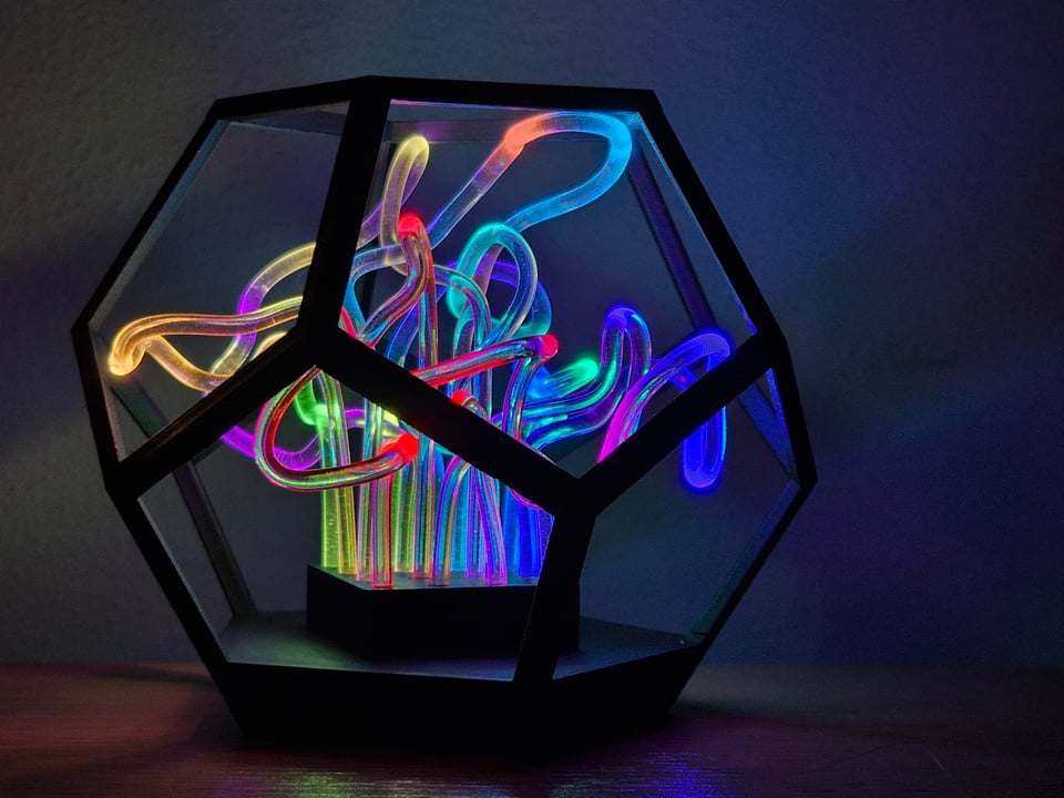 Dwelf desk lamp with rainbow fiber-optic tubes in a black geometric glass enclosure