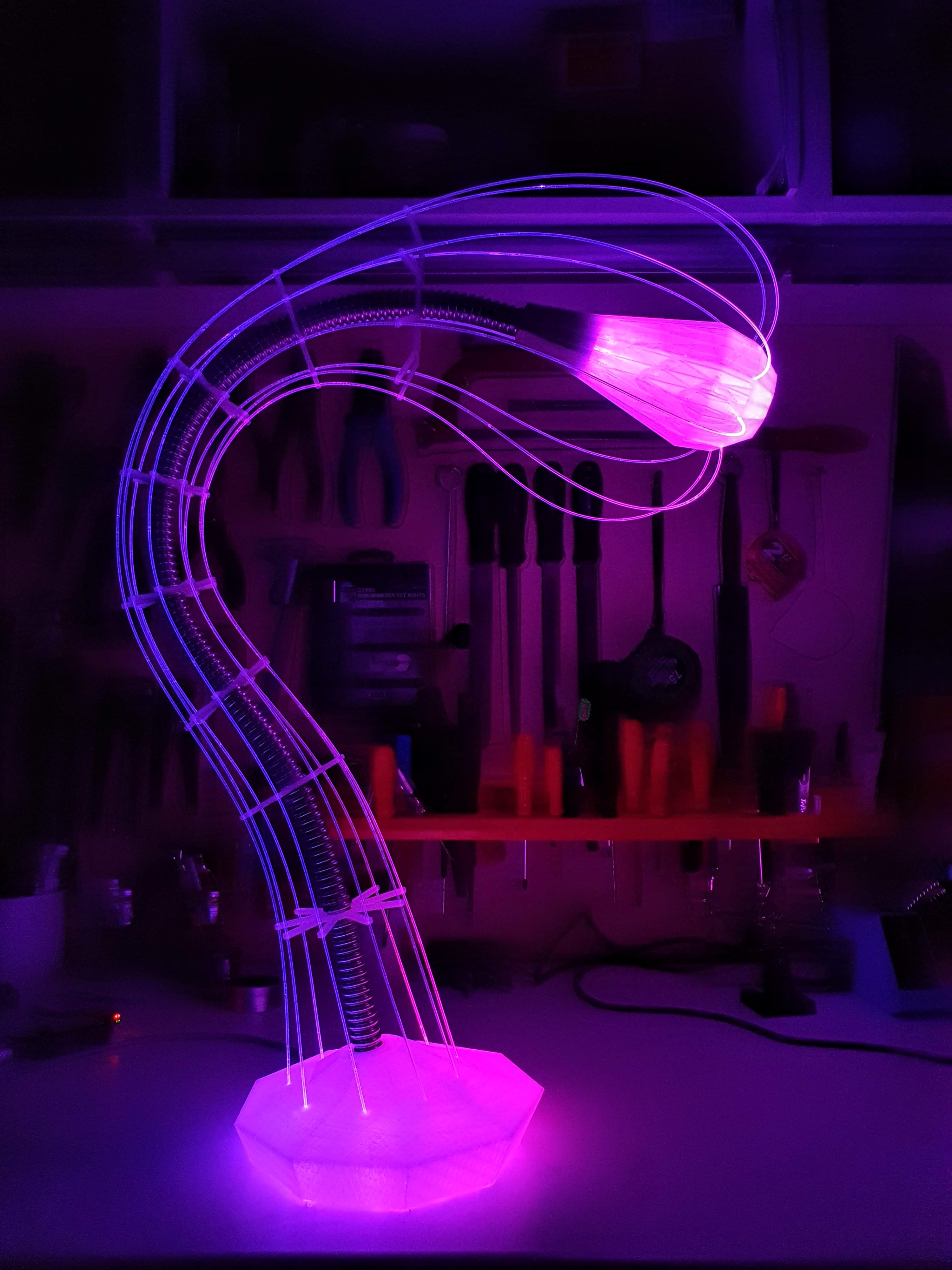IXFID — purple glowing curved desk lamp in a workshop